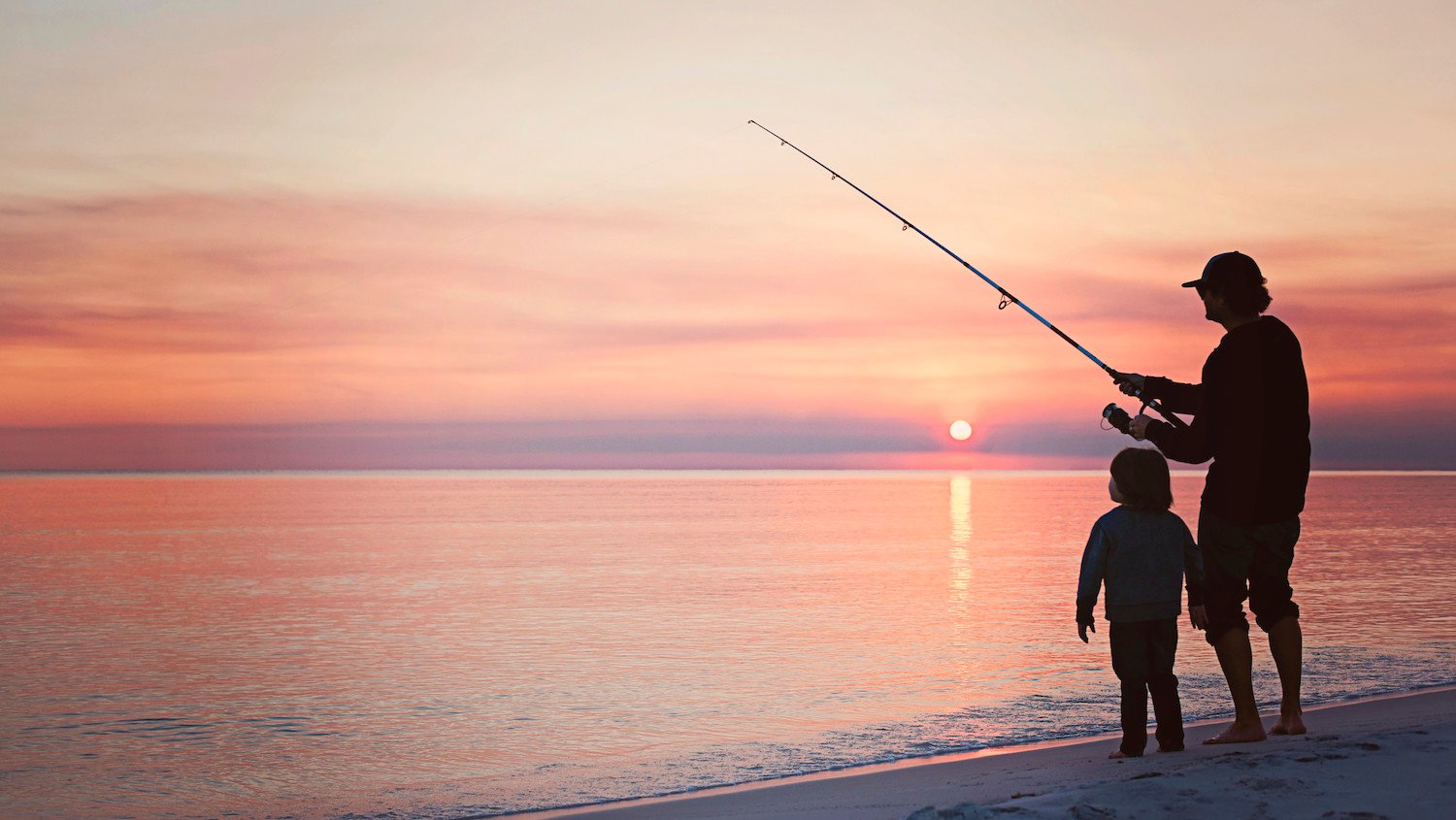 Man and child fishing during sunset