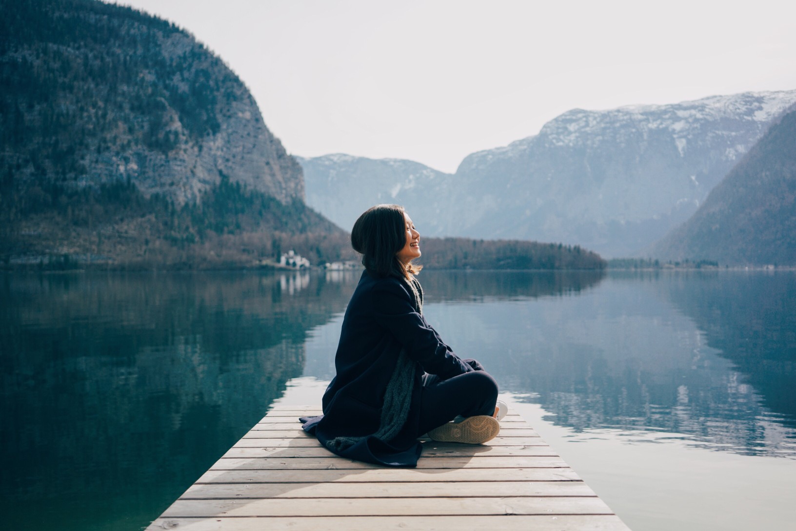 woman sitting by the lake smiling