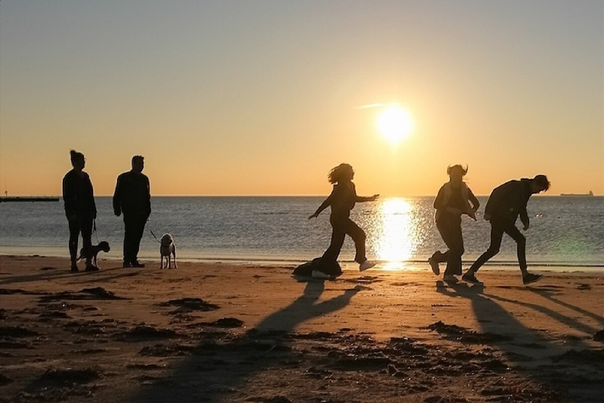 People running on the beach happy