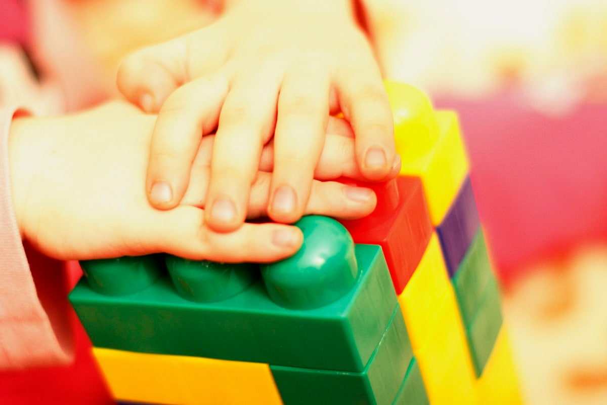 Close up of child's hands playing with colorful interlocking block toys