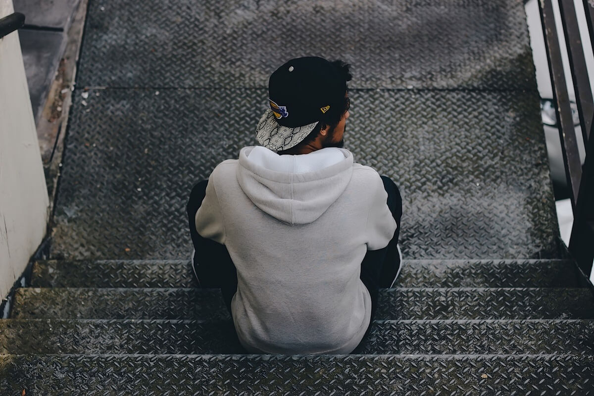 millennial sitting on iron subway stairs