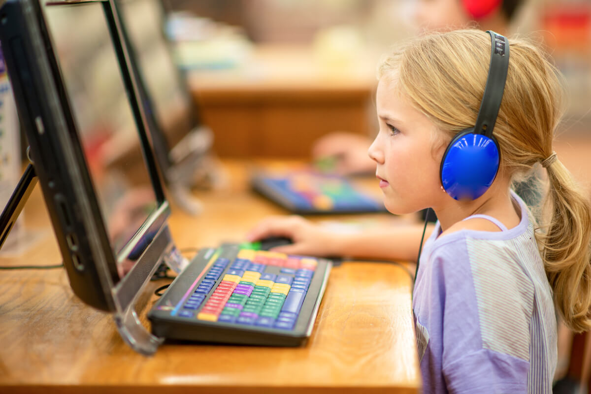 young 2E elementary student in front of computer wearing headphones