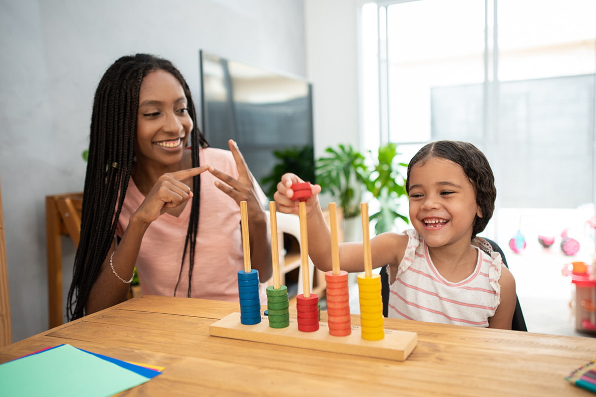 ABA provider with young girl using Montessori inspired stacking toy