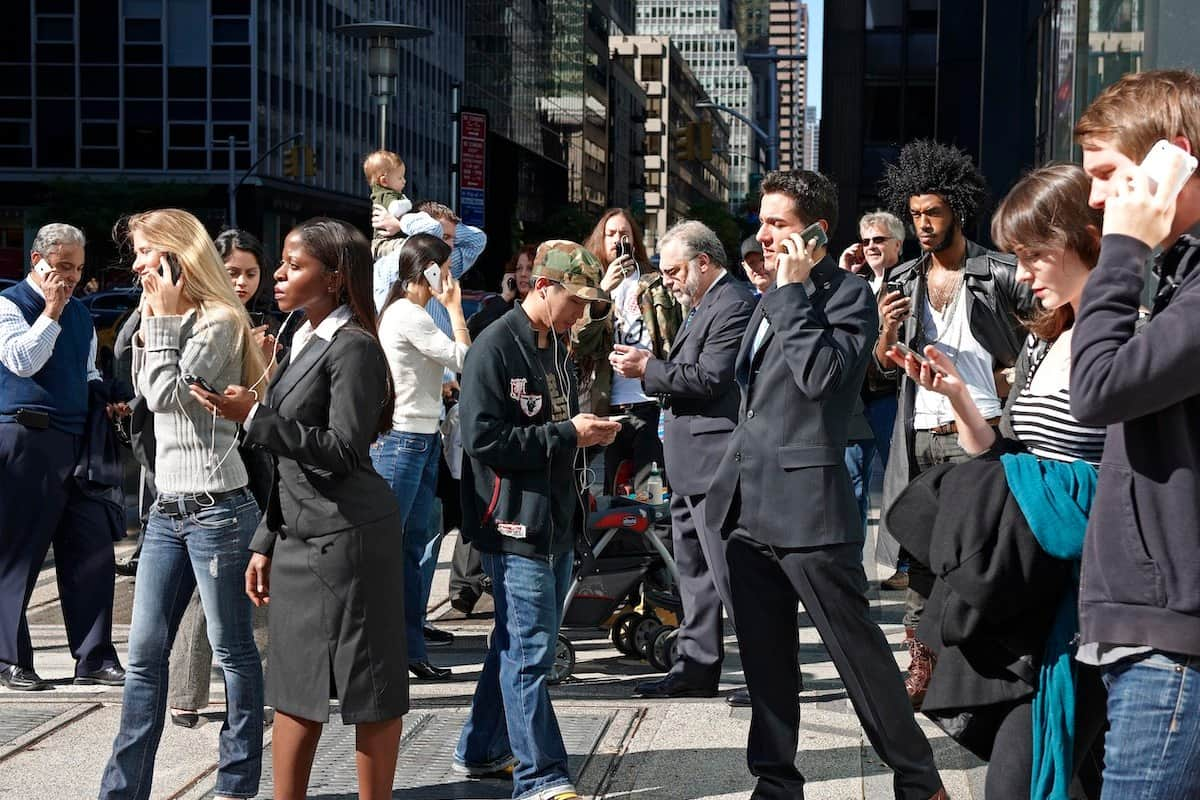 People using mobile phones in a busy city street