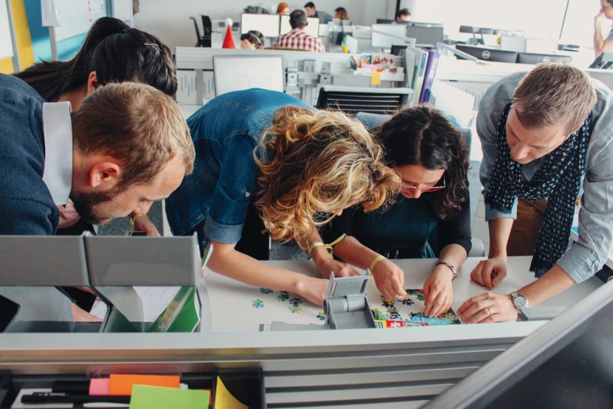 Employees in an office working on a puzzle