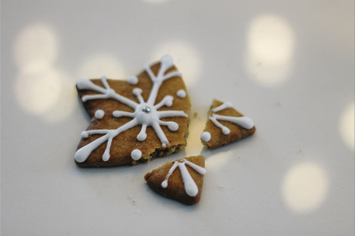 Christmas cookie star broken on gray background with lights shining