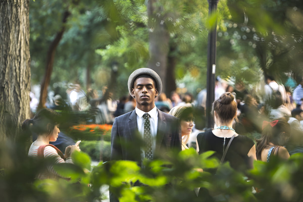 African man with his eyes closed at a busy event