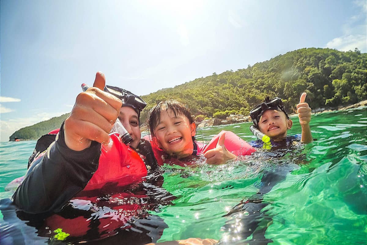 Mother and children smiling and posing while scuba diving