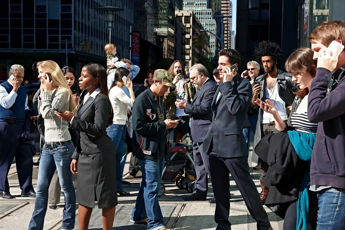 Busy city street with most pedestrians walking while talking on their phones