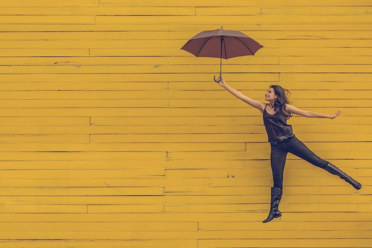 woman jumping happy with umbrella