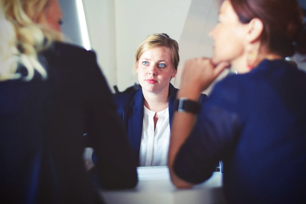 woman being interviewed by two women over shoulder